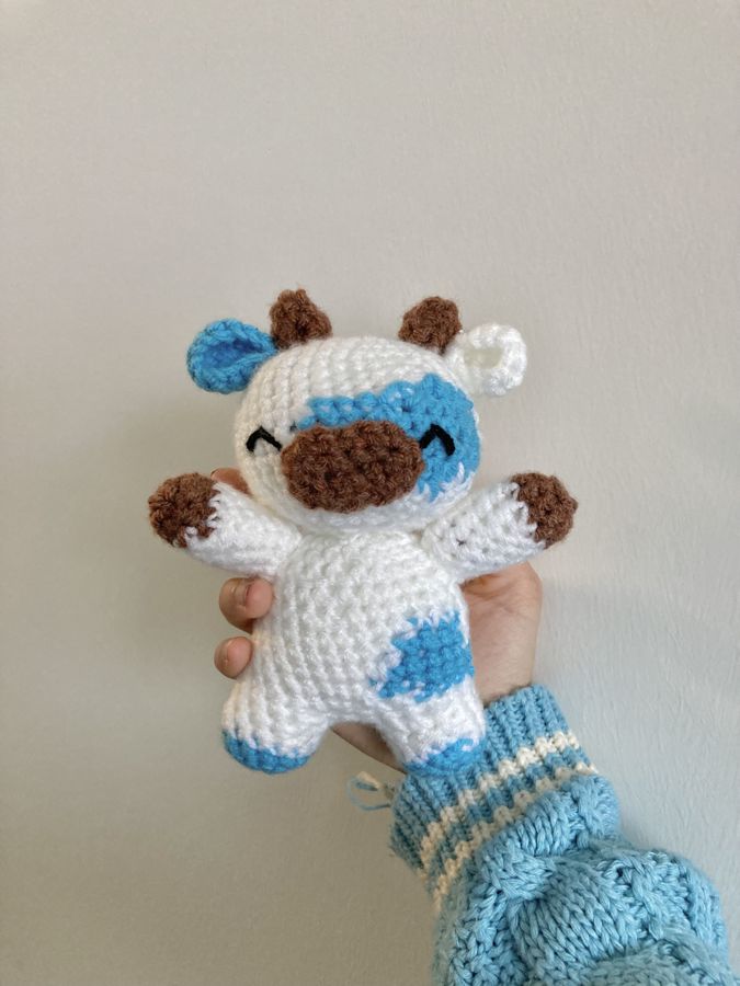 A crocheted cow Chloe made, white with blue and brown patches